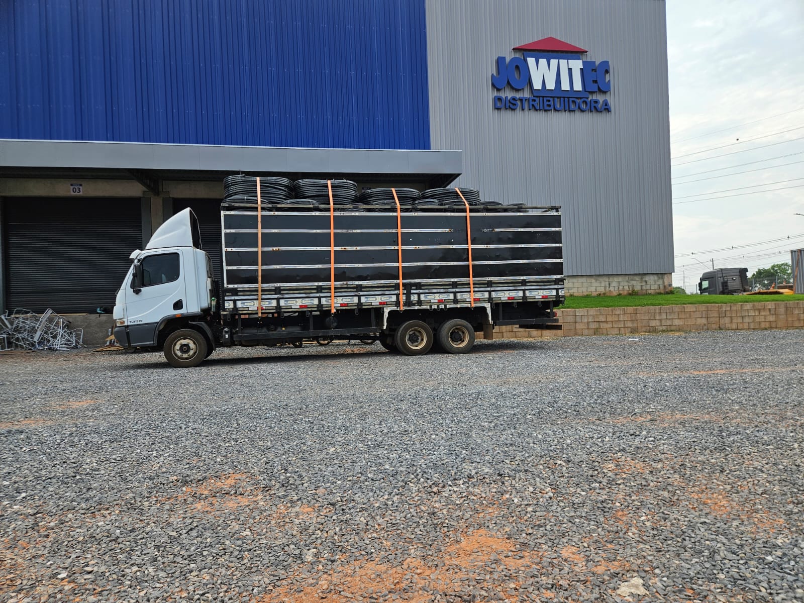 Caminhão SAN-PLAST entregando rolos em distribuidor parceiro